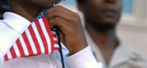closeup image of a man holding a small american flag near his neck