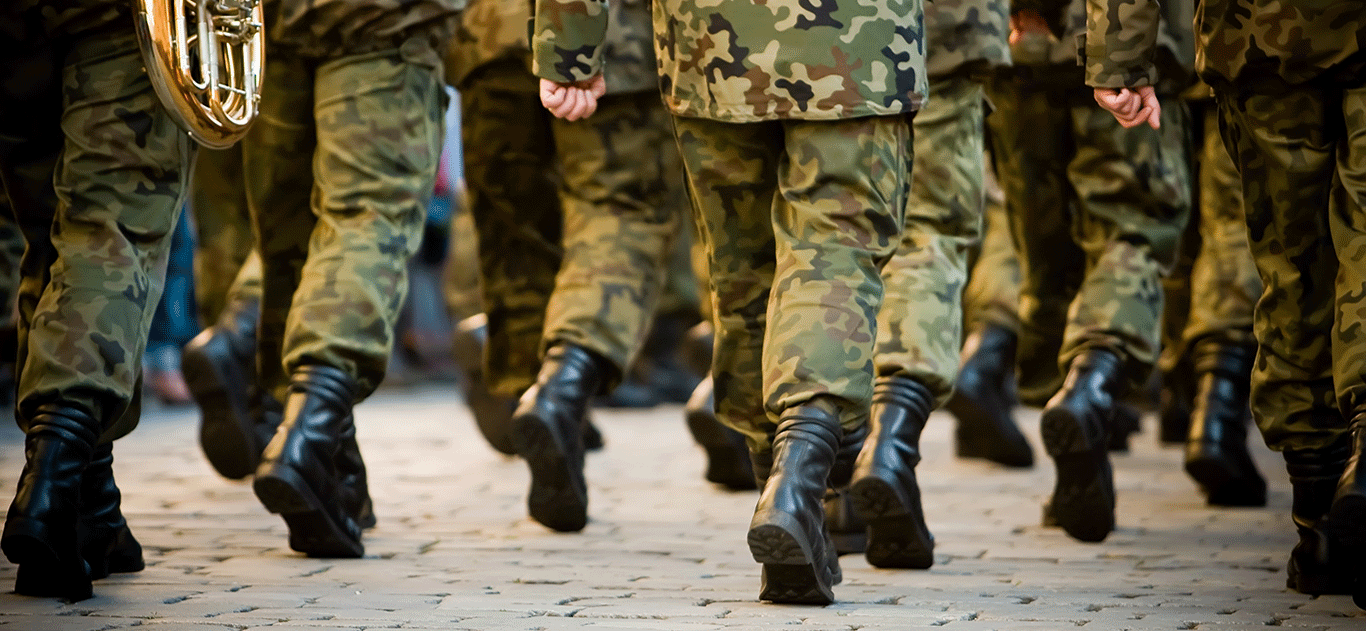 legs of soldiers in camo marching with instruments in hand