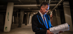 man holding ream of museum of the bible paper in parking garage